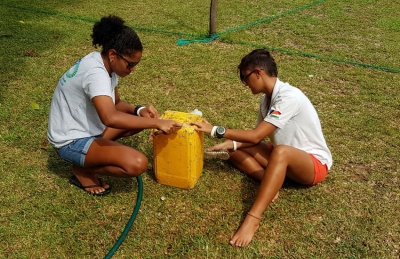 Camila and Athina carefully clean the old jerry cans 